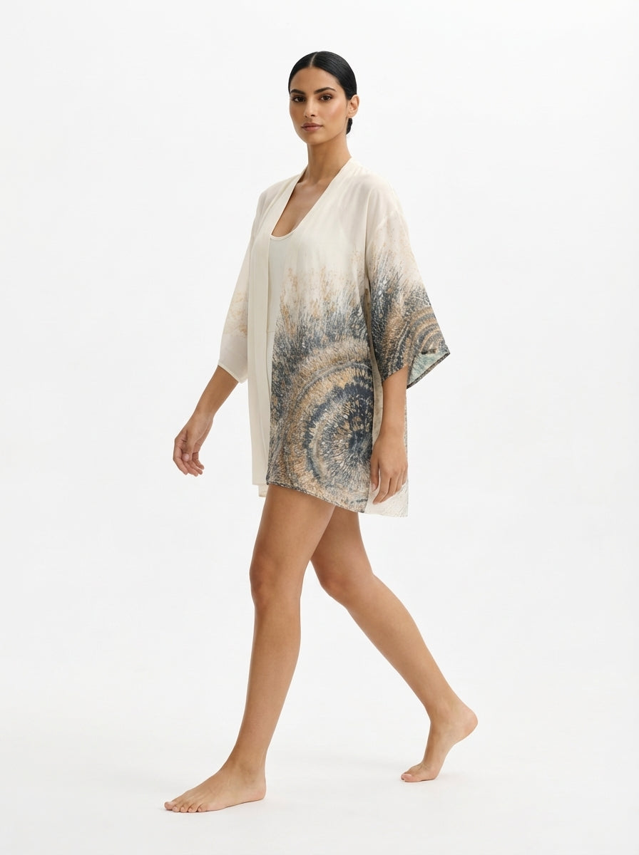 Woman wearing a patterned kimono-style garment on a white background