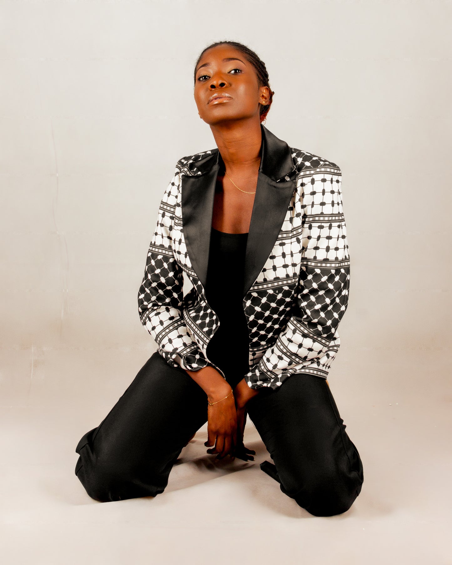 Statement black and white blazer from the HORRA collection by MNour Design, inspired by the keffiyeh pattern and tailored with a sleek satin lapel. A bold fusion of tradition and modernity for the empowered woman. Discover more at www.mnourdesign.com.