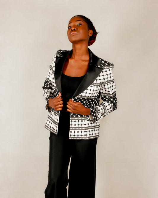 Statement black and white blazer from the HORRA collection by MNour Design, inspired by the keffiyeh pattern and tailored with a sleek satin lapel. A bold fusion of tradition and modernity for the empowered woman. Discover more at www.mnourdesign.com.