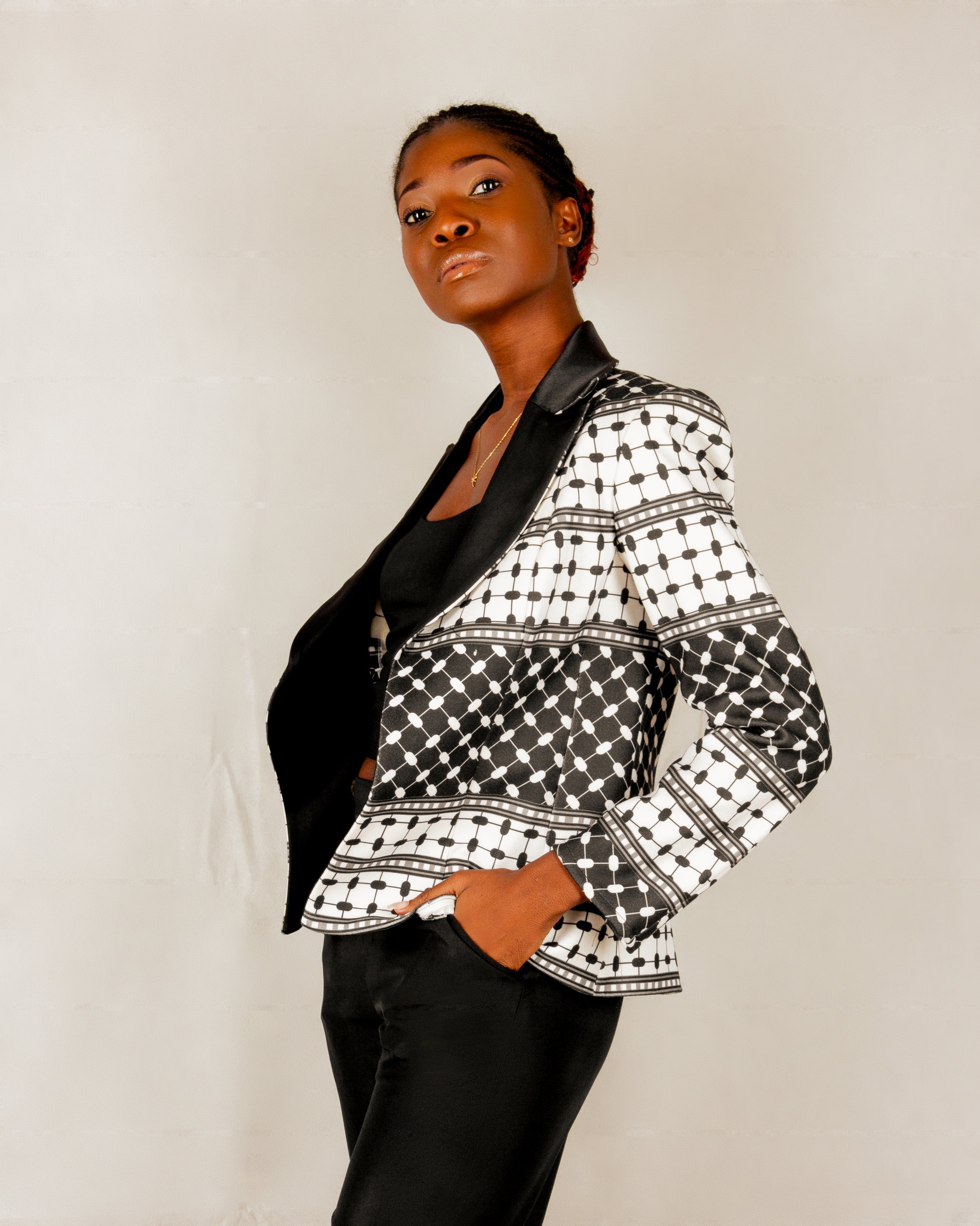Statement black and white blazer from the HORRA collection by MNour Design, inspired by the keffiyeh pattern and tailored with a sleek satin lapel. A bold fusion of tradition and modernity for the empowered woman. Discover more at www.mnourdesign.com.
