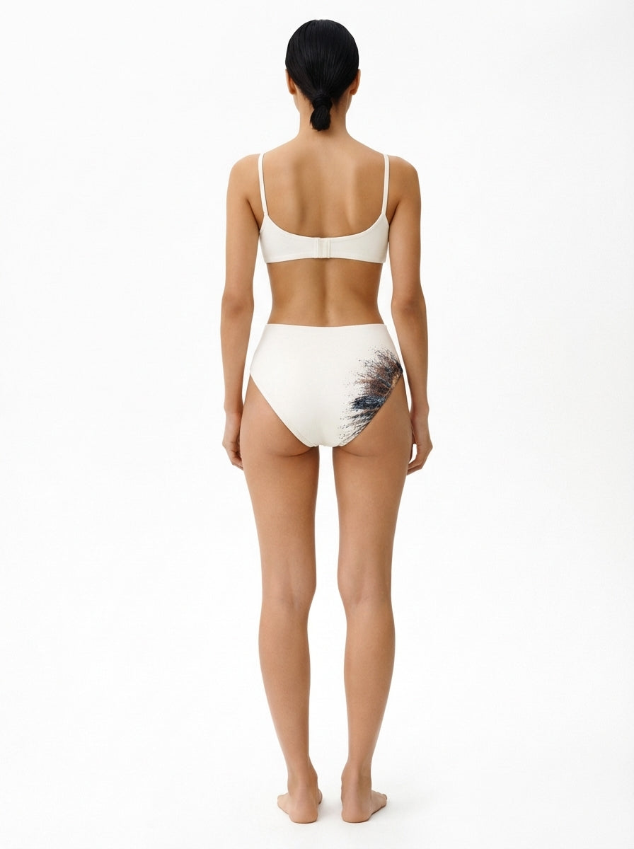 Woman wearing a white bikini with a floral pattern on a white background