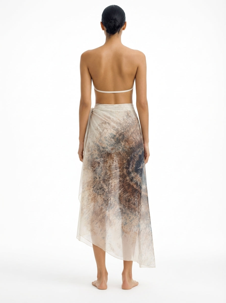 Woman wearing a long, patterned skirt on a white background