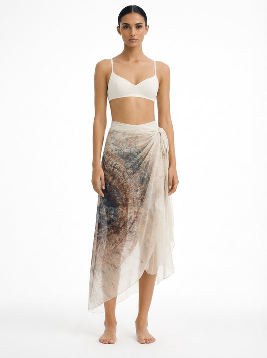 Woman wearing a white top and patterned skirt on a white background