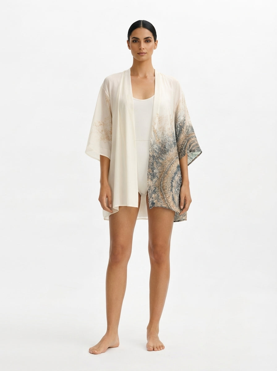 Woman wearing a light-colored kimono-style garment on a white background