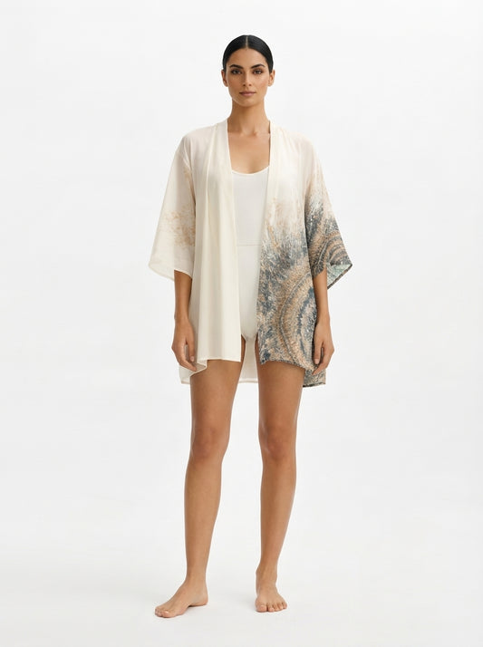 Woman wearing a light-colored kimono-style garment on a white background