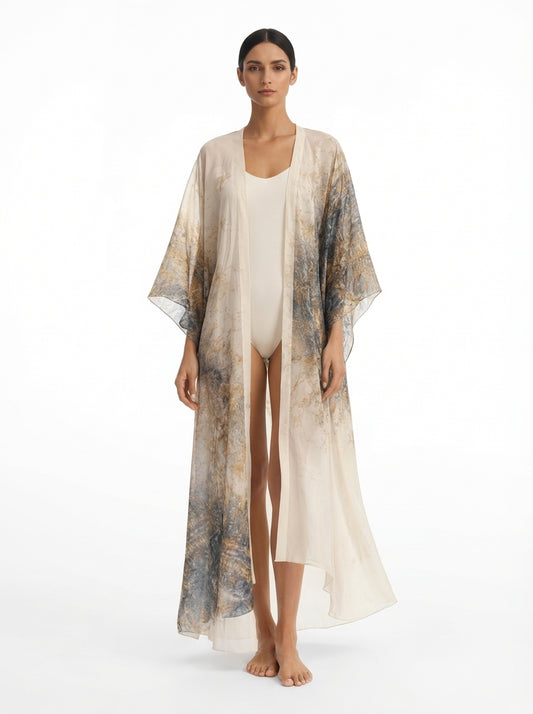Woman wearing a long, sheer kimono-style garment over a white outfit on a white background