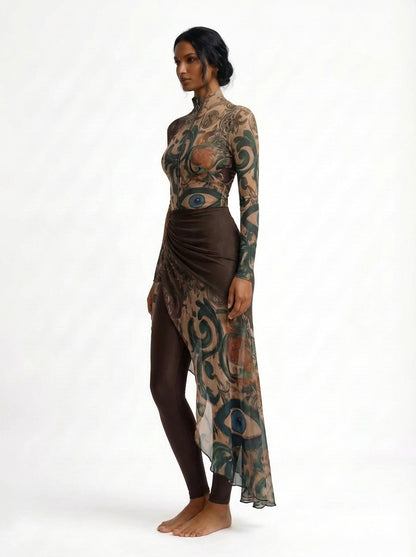 Woman wearing a long, patterned dress with a white background