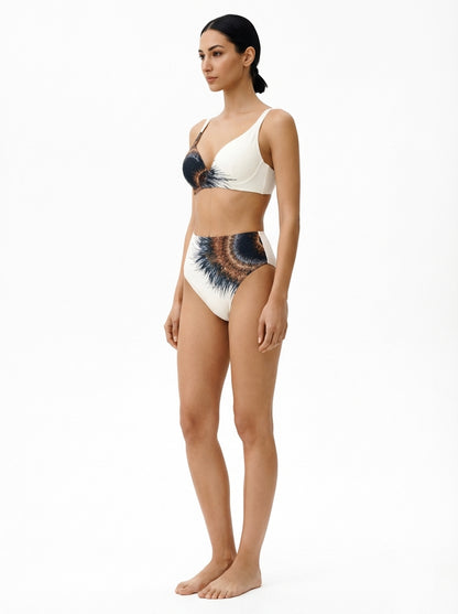 Woman wearing a white bikini with blue and black abstract design on a white background