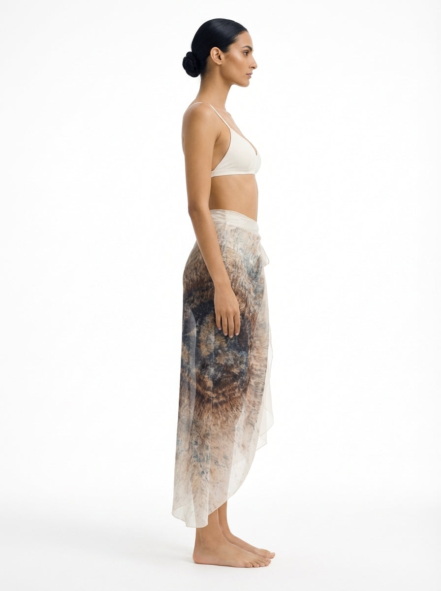 Woman wearing a white bikini and patterned cover-up on a white background