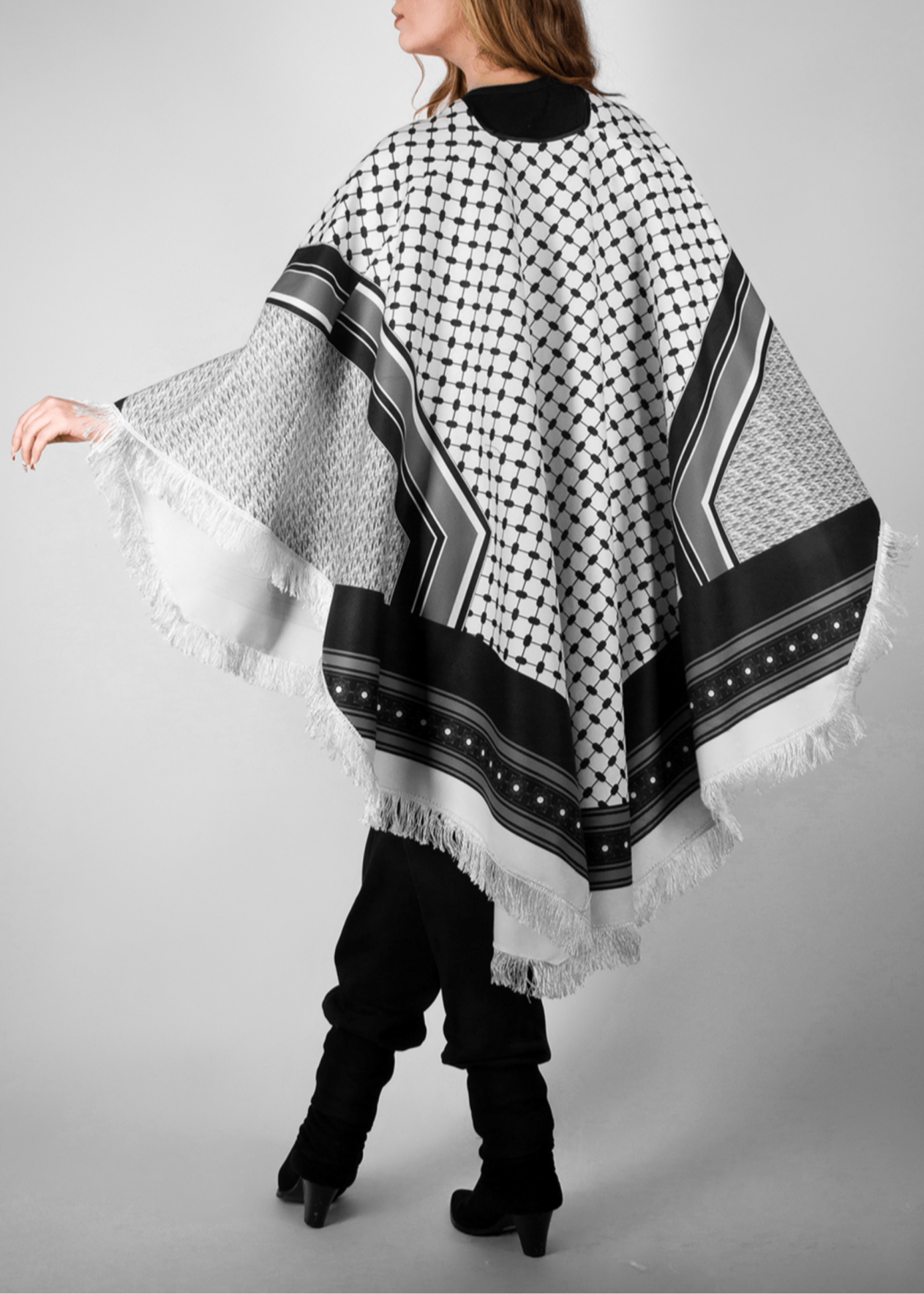 Elegant black and white poncho from the HORRA collection by MNour Design, inspired by traditional Palestinian keffiyeh patterns. Featuring intricate geometric details and delicate fringe edges, this timeless piece blends cultural heritage with modern sophistication. Discover more at www.mnourdesign.com