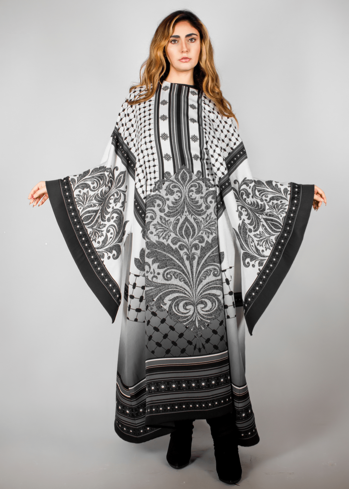 Elegant black and white abaya from the HORRA collection by MNour Design, featuring intricate architectural patterns and cultural motifs. A sophisticated blend of heritage and modern fashion. Discover more at www.mnourdesign.com
