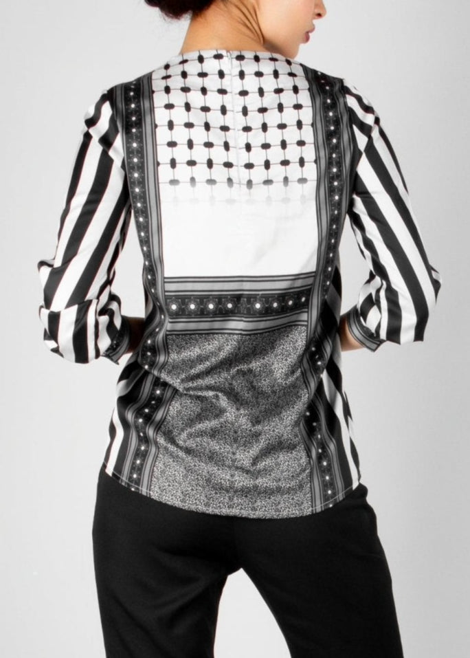 Modern black and white blouse from the HORRA collection by MNour Design, featuring keffiyeh-inspired patterns and bold stripes. A sophisticated fusion of heritage and contemporary fashion. Explore more at www.mnourdesign.com