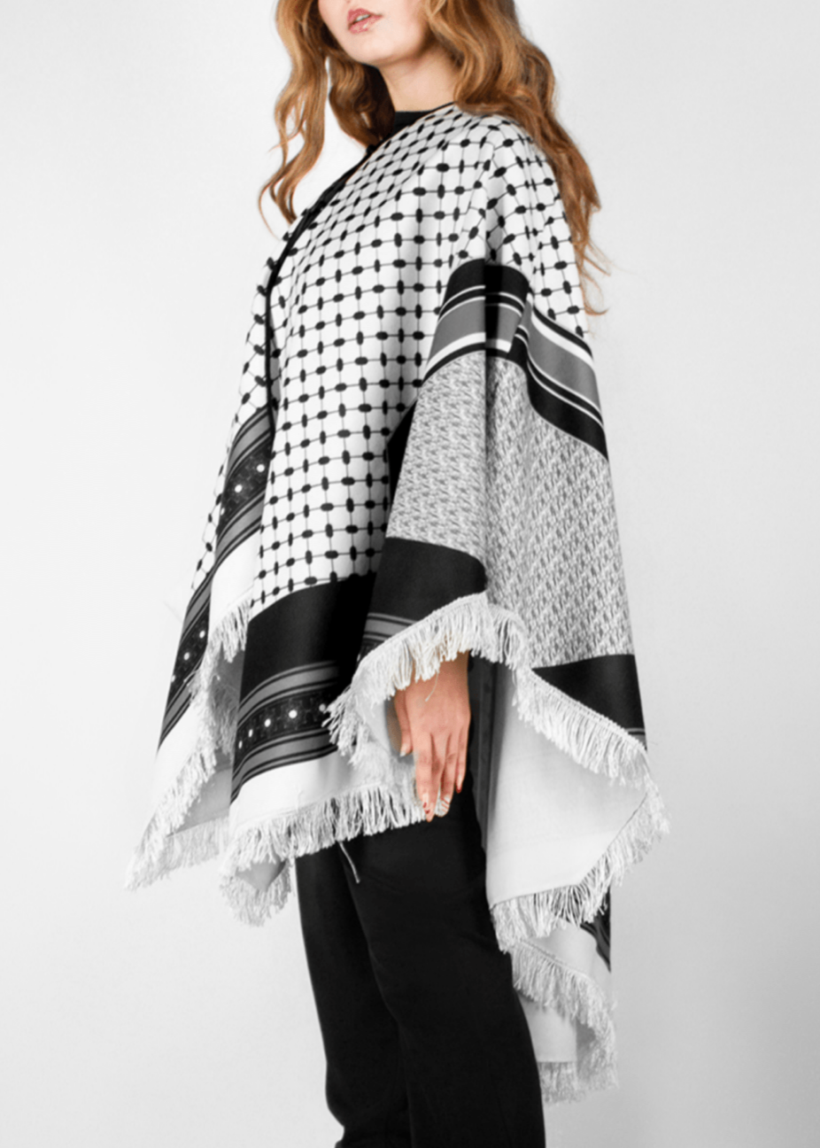Elegant black and white poncho from the HORRA collection by MNour Design, inspired by traditional Palestinian keffiyeh patterns. Featuring intricate geometric details and delicate fringe edges, this timeless piece blends cultural heritage with modern sophistication. Discover more at www.mnourdesign.com 