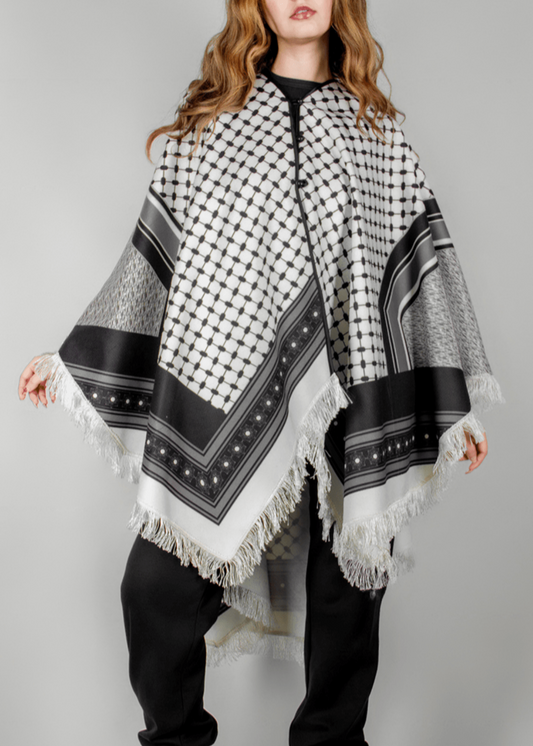 Elegant black and white poncho from the HORRA collection by MNour Design, inspired by traditional Palestinian keffiyeh patterns. Featuring intricate geometric details and delicate fringe edges, this timeless piece blends cultural heritage with modern sophistication. Discover more at www.mnourdesign.com
