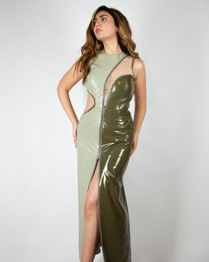 Sleek and modern olive-green evening gown by MNour Design, featuring a glossy latex-like finish, asymmetrical cut-out details, and a high slit adorned with shimmering embellishments. A bold fusion of elegance and contemporary fashion. Explore this statement piece at www.mnourdesign.com