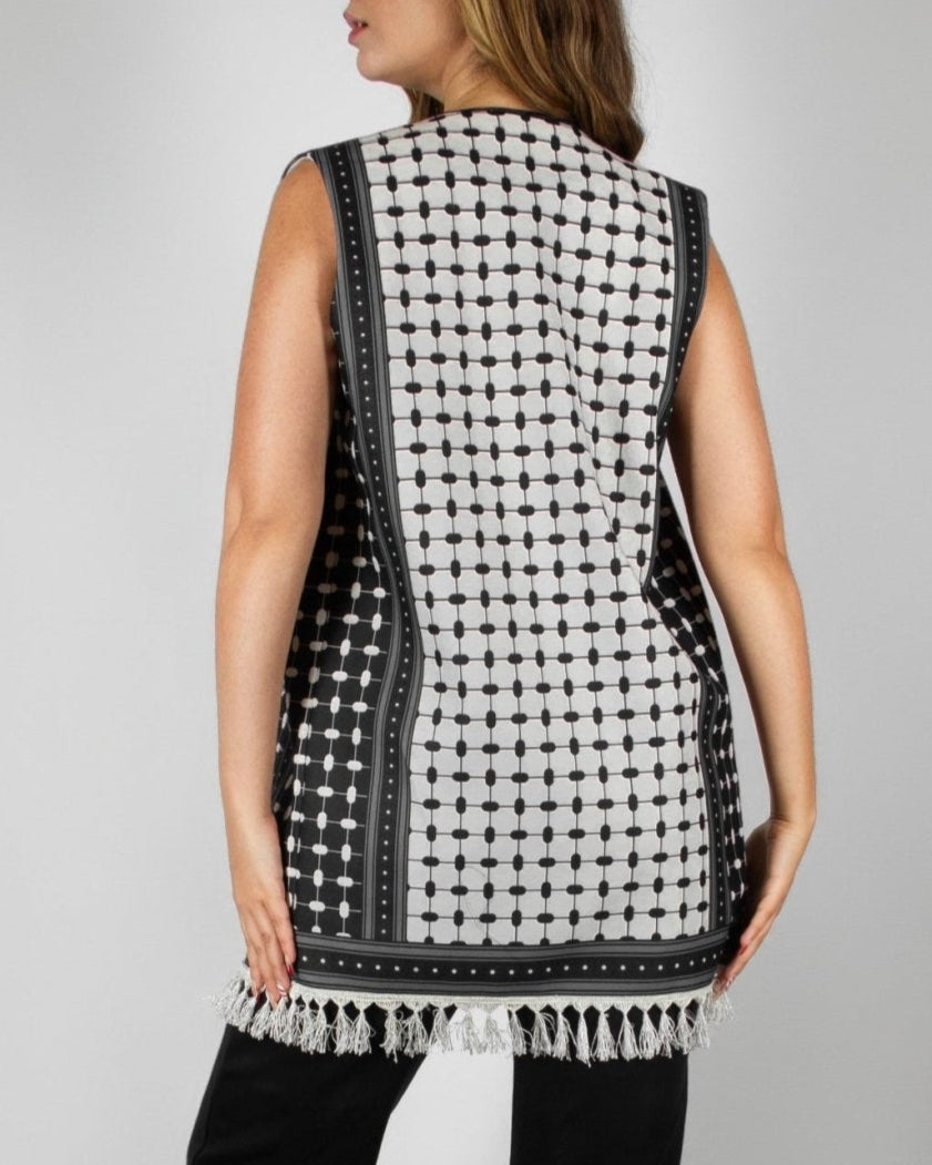 Modern black and white vest from the HORRA collection by MNour Design, featuring intricate geometric and traditional patterns with delicate fringe detailing. Styled over a sleek black ensemble for a contemporary yet culturally inspired look. Discover more at www.mnourdesign.com