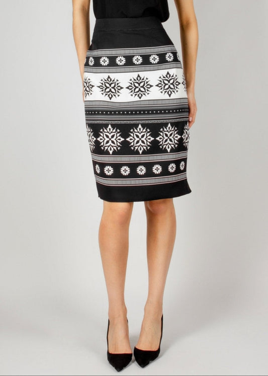 Chic black and white pencil skirt from the HORRA collection by MNour Design, featuring traditional keffiyeh-inspired embroidery. Paired with a sleek black V-neck top and classic black heels for an elegant yet modern look. Discover more at www.mnourdesign.com.