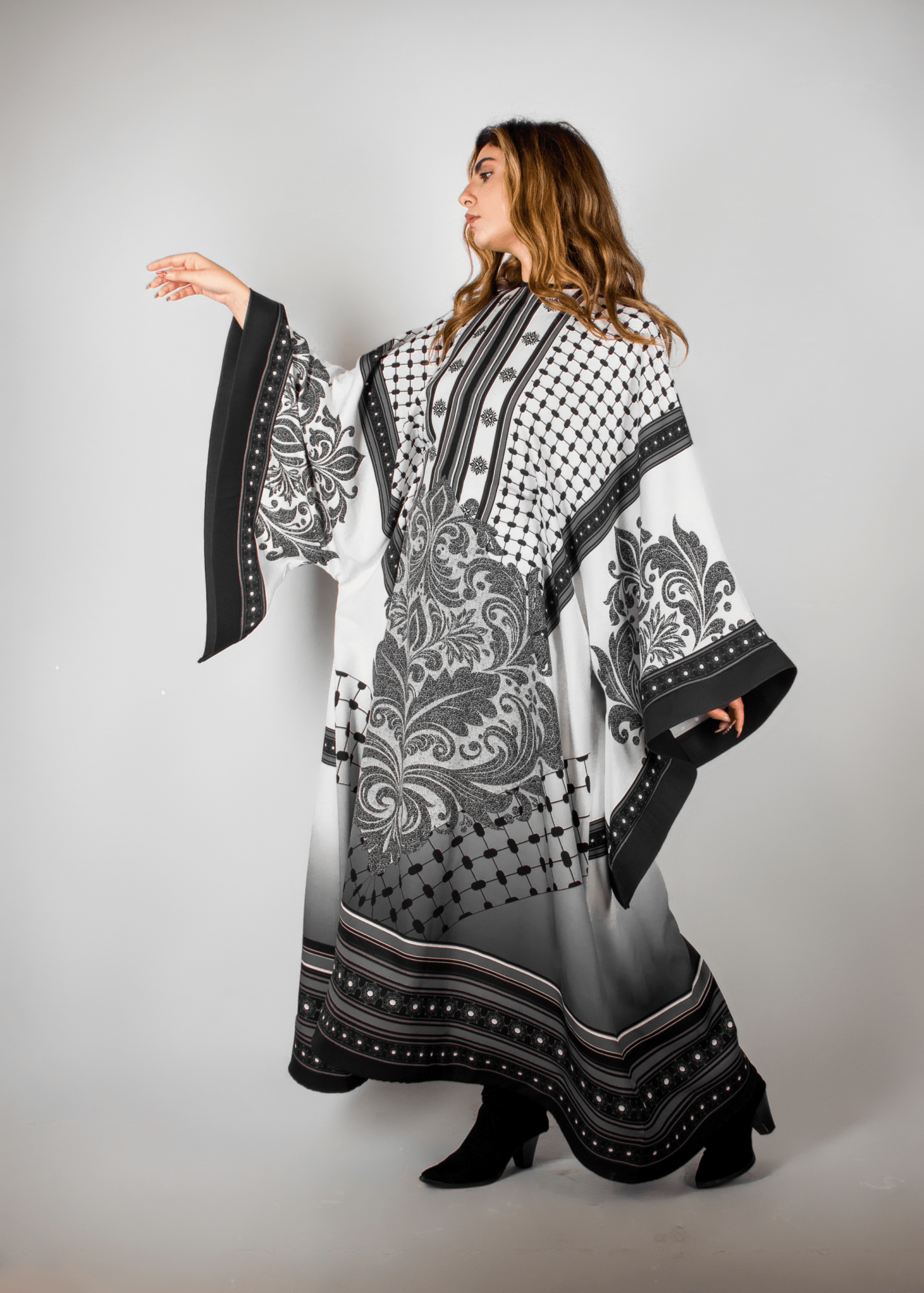 Stunning black and white abaya from the HORRA collection by MNour Design, featuring intricate architectural and cultural motifs. A graceful fusion of heritage and contemporary elegance. Explore more at www.mnourdesign.com