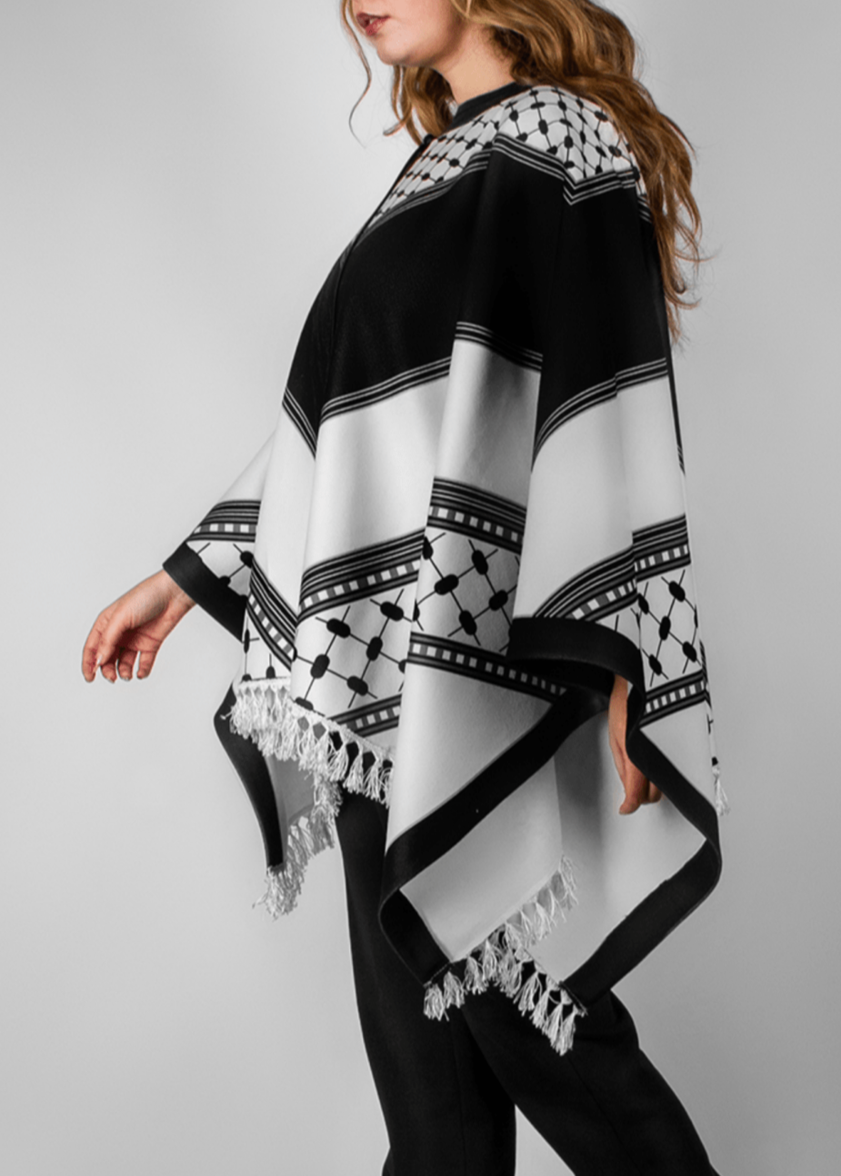 Elegant black and white poncho from the HORRA collection by MNour Design, inspired by traditional Palestinian keffiyeh patterns. Featuring intricate geometric details and delicate fringe edges, this timeless piece blends cultural heritage with modern sophistication. Discover more at www.mnourdesign.com