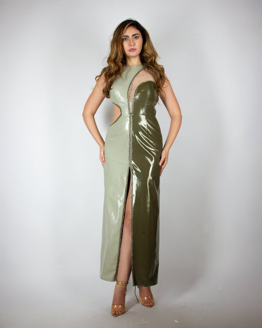 Sleek and modern olive-green evening gown by MNour Design, featuring a glossy latex-like finish, asymmetrical cut-out details, and a high slit adorned with shimmering embellishments. A bold fusion of elegance and contemporary fashion. Explore this statement piece at www.mnourdesign.com