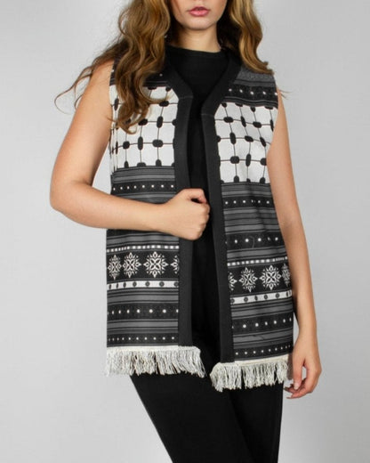 Modern black and white vest from the HORRA collection by MNour Design, featuring intricate geometric and traditional patterns with delicate fringe detailing. Styled over a sleek black ensemble for a contemporary yet culturally inspired look. Discover more at www.mnourdesign.com