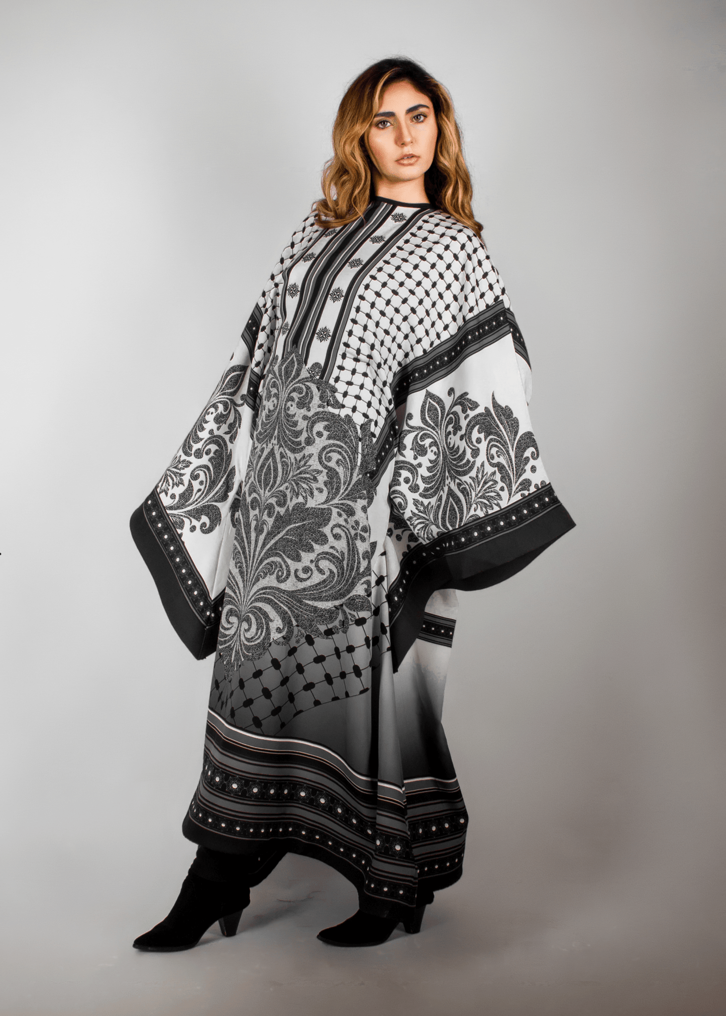Elegant black and white abaya from the HORRA collection by MNour Design, featuring intricate architectural patterns and cultural motifs. A sophisticated blend of heritage and modern fashion. Discover more at www.mnourdesign.com