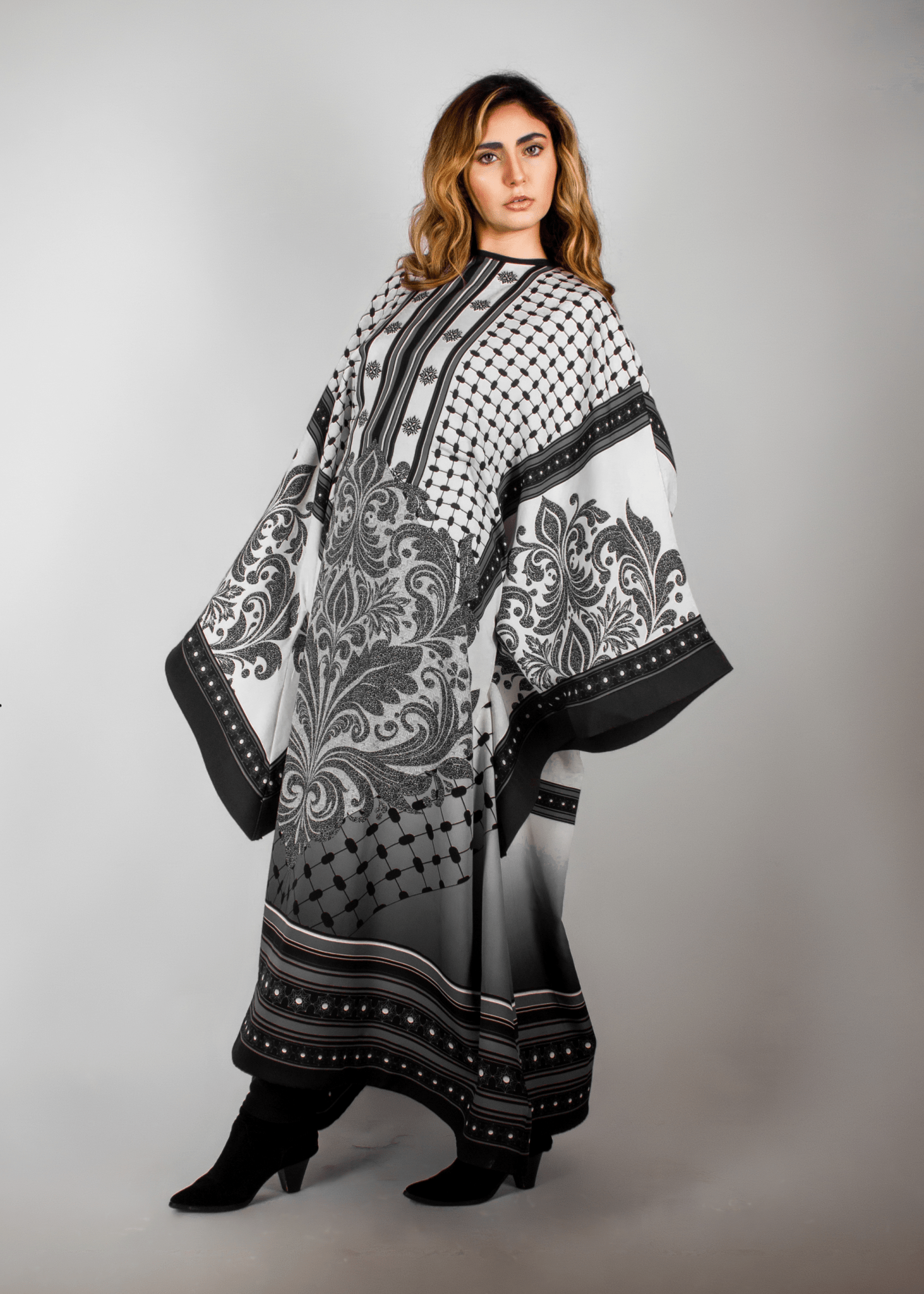 Elegant black and white abaya from the HORRA collection by MNour Design, featuring intricate architectural patterns and cultural motifs. A sophisticated blend of heritage and modern fashion. Discover more at www.mnourdesign.com