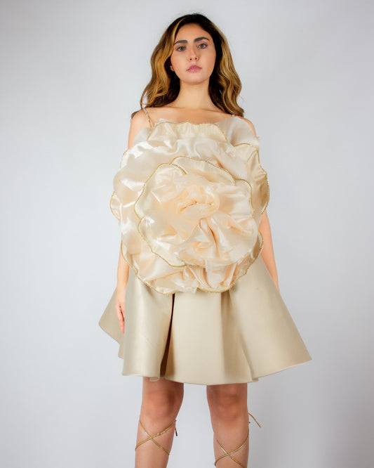Luxurious champagne-colored mini dress by MNour Design, featuring a voluminous satin skirt and an oversized sculptural rose detail on the bodice with gold-trimmed petals. A bold, artistic statement for elegant occasions. Discover this exclusive couture piece at www.mnourdesign.com.