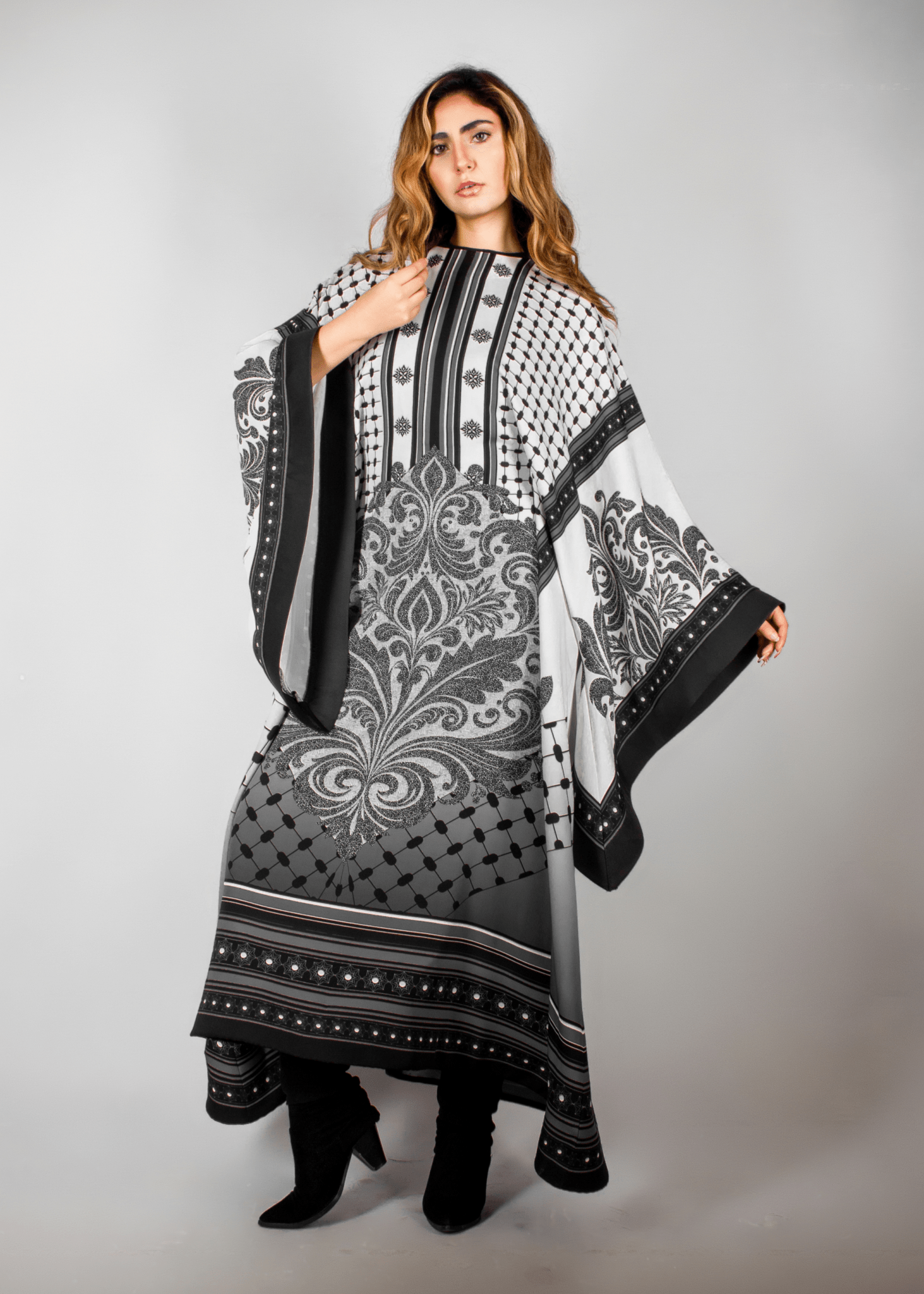 Elegant black and white abaya from the HORRA collection by MNour Design, featuring intricate architectural patterns and cultural motifs. A sophisticated blend of heritage and modern fashion. Discover more at www.mnourdesign.com