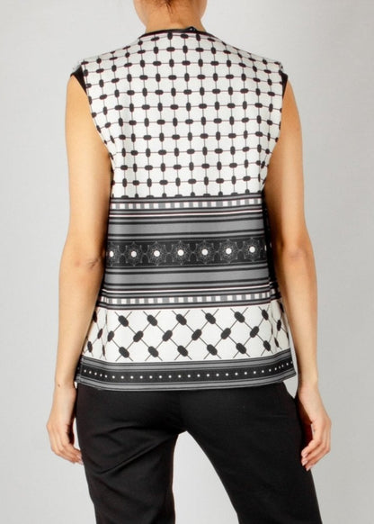 Modern sleeveless vest from the HORRA collection by MNour Design, featuring a striking black-and-white keffiyeh-inspired pattern. Styled with a sleek black satin blouse and tailored trousers for a bold and sophisticated look. Discover more at www.mnourdesign.com