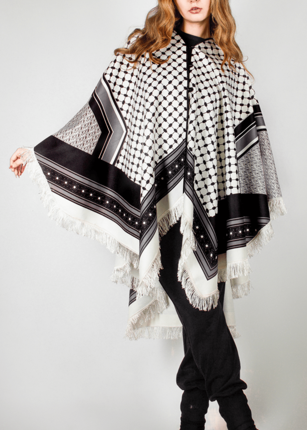 Elegant black and white poncho from the HORRA collection by MNour Design, inspired by traditional Palestinian keffiyeh patterns. Featuring intricate geometric details and delicate fringe edges, this timeless piece blends cultural heritage with modern sophistication. Discover more at www.mnourdesign.com