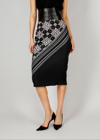 Elegant black midi skirt from the HORRA collection by MNour Design, featuring a bold asymmetrical keffiyeh-inspired pattern. Paired with a sleek black top and a structured leather waist belt for a modern, powerful look. Explore the full collection at www.mnourdesign.com.