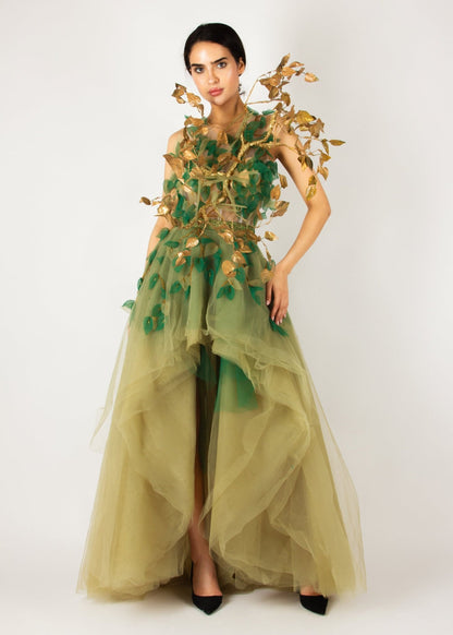 Enchanting nature-inspired gown by MNour Design, featuring a flowing olive-green tulle skirt with a high-low cut and an intricately designed bodice adorned with gold and green leaf appliqués. A breathtaking fusion of fashion and artistry. Discover this exclusive design at www.mnourdesign.com