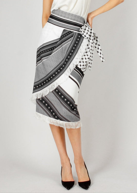 Chic wrap-style midi skirt from the HORRA collection by MNour Design, featuring a striking black-and-white traditional pattern with fringe detailing and a statement side tie. Paired with a sleek satin top and classic heels for an effortlessly elegant look. Explore more at www.mnourdesign.com