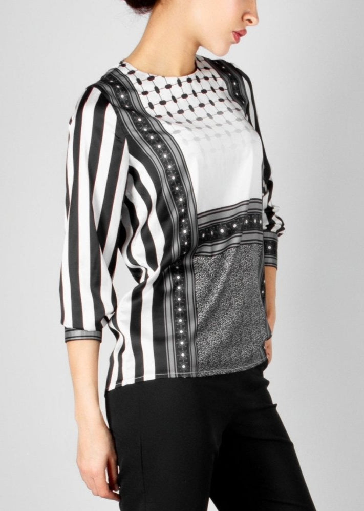 Modern black and white blouse from the HORRA collection by MNour Design, featuring keffiyeh-inspired patterns and bold stripes. A sophisticated fusion of heritage and contemporary fashion. Explore more at www.mnourdesign.com