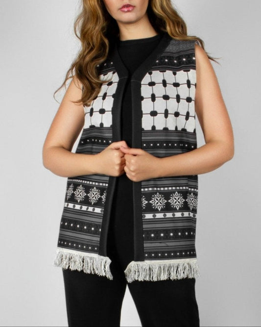 Modern black and white vest from the HORRA collection by MNour Design, featuring intricate geometric and traditional patterns with delicate fringe detailing. Styled over a sleek black ensemble for a contemporary yet culturally inspired look. Discover more at www.mnourdesign.com