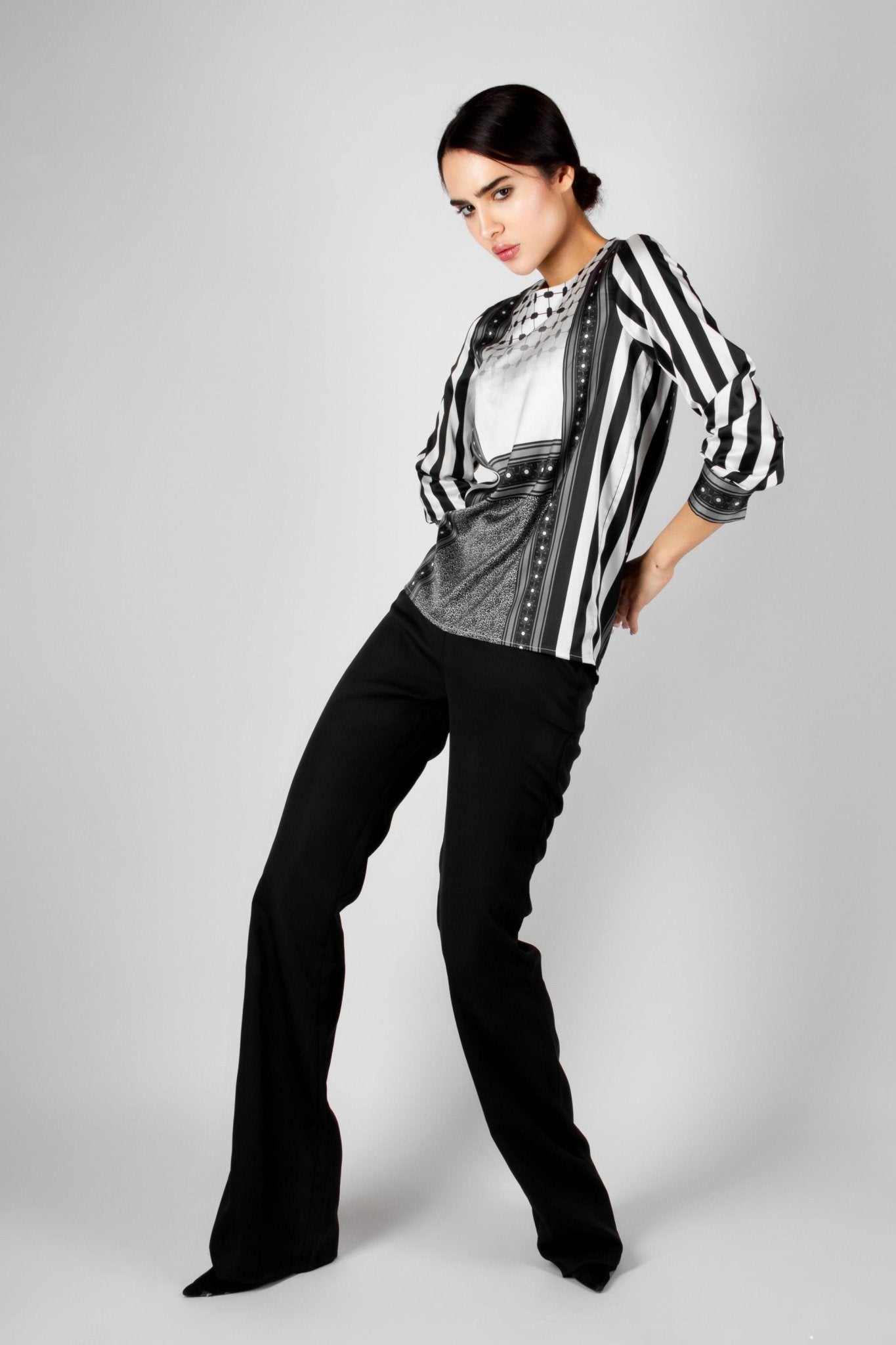 Modern black and white blouse from the HORRA collection by MNour Design, featuring keffiyeh-inspired patterns and bold stripes. A sophisticated fusion of heritage and contemporary fashion. Explore more at www.mnourdesign.com