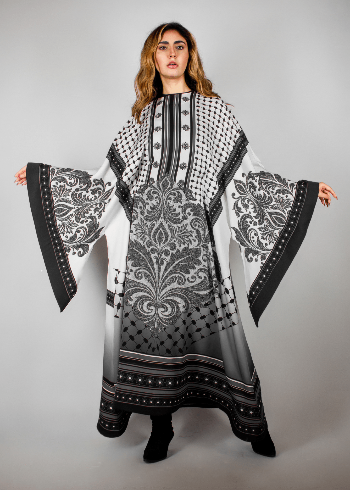 Elegant black and white abaya from the HORRA collection by MNour Design, featuring intricate architectural patterns and cultural motifs. A sophisticated blend of heritage and modern fashion. Discover more at www.mnourdesign.com