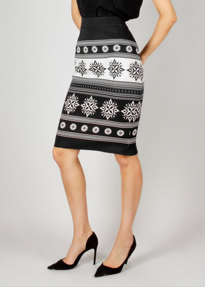 Chic black and white pencil skirt from the HORRA collection by MNour Design, featuring traditional keffiyeh-inspired embroidery. Paired with a sleek black V-neck top and classic black heels for an elegant yet modern look. Discover more at www.mnourdesign.com.