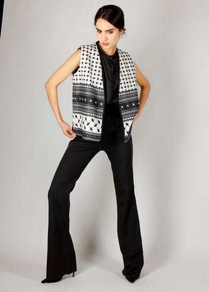 Modern sleeveless vest from the HORRA collection by MNour Design, featuring a striking black-and-white keffiyeh-inspired pattern. Styled with a sleek black satin blouse and tailored trousers for a bold and sophisticated look. Discover more at www.mnourdesign.com