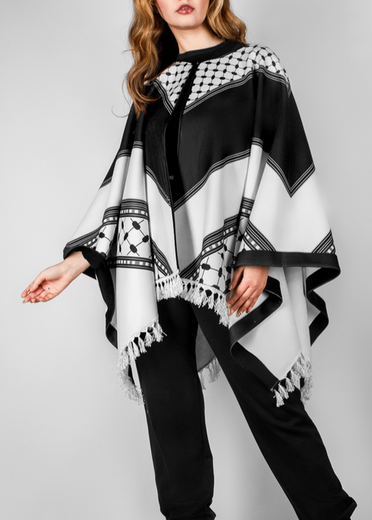 Elegant black and white poncho from the HORRA collection by MNour Design, inspired by traditional Palestinian keffiyeh patterns. Featuring intricate geometric details and delicate fringe edges, this timeless piece blends cultural heritage with modern sophistication. Discover more at www.mnourdesign.com